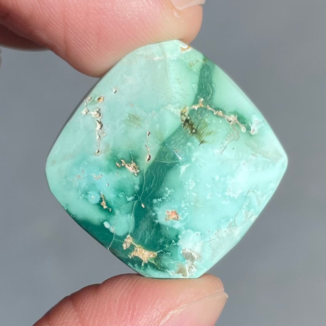 A loose, cushion cabochon cut variscite stone from Utah, USA.