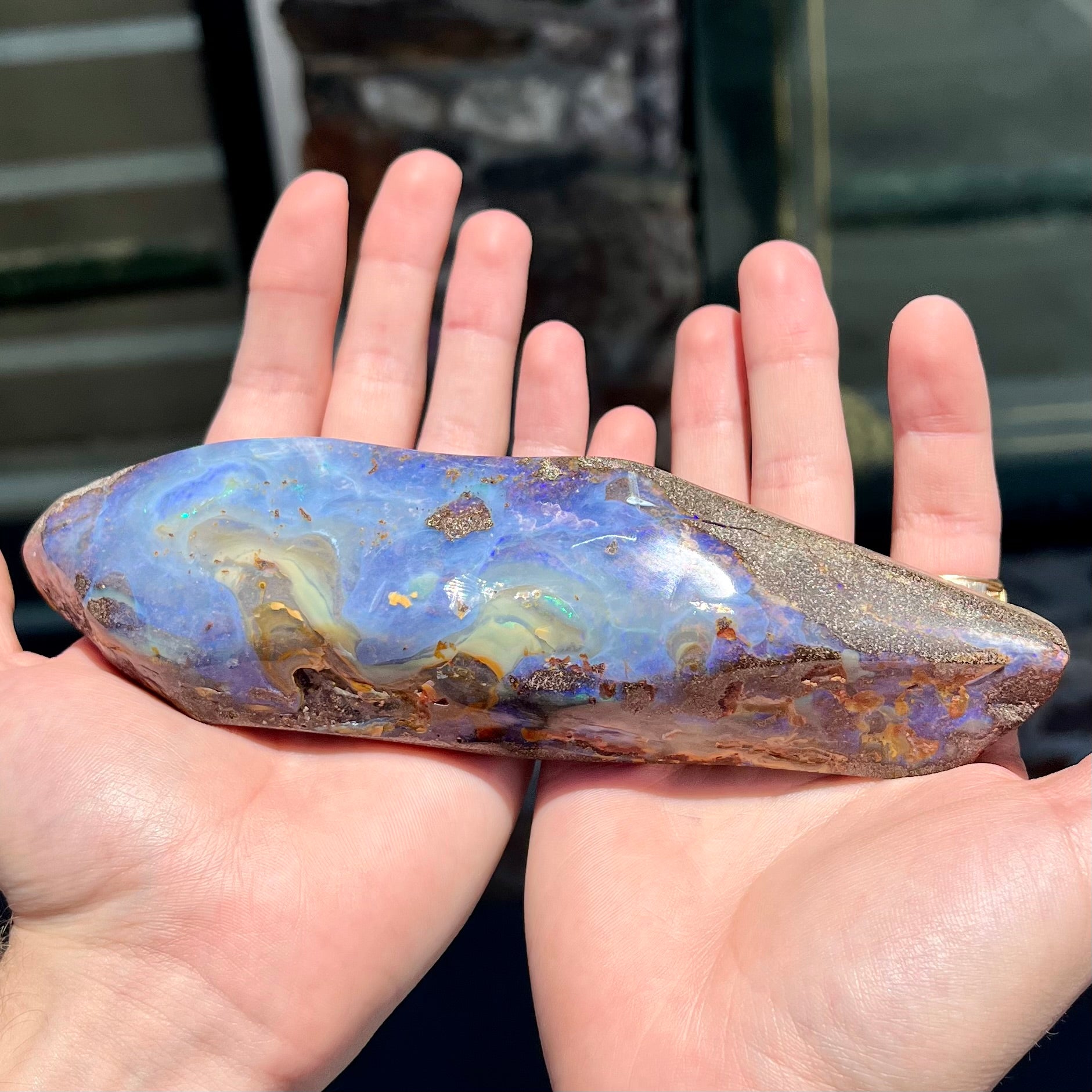 A 7 inch long polished blue Quilpie boulder opal specimen from Queensland, Australia.