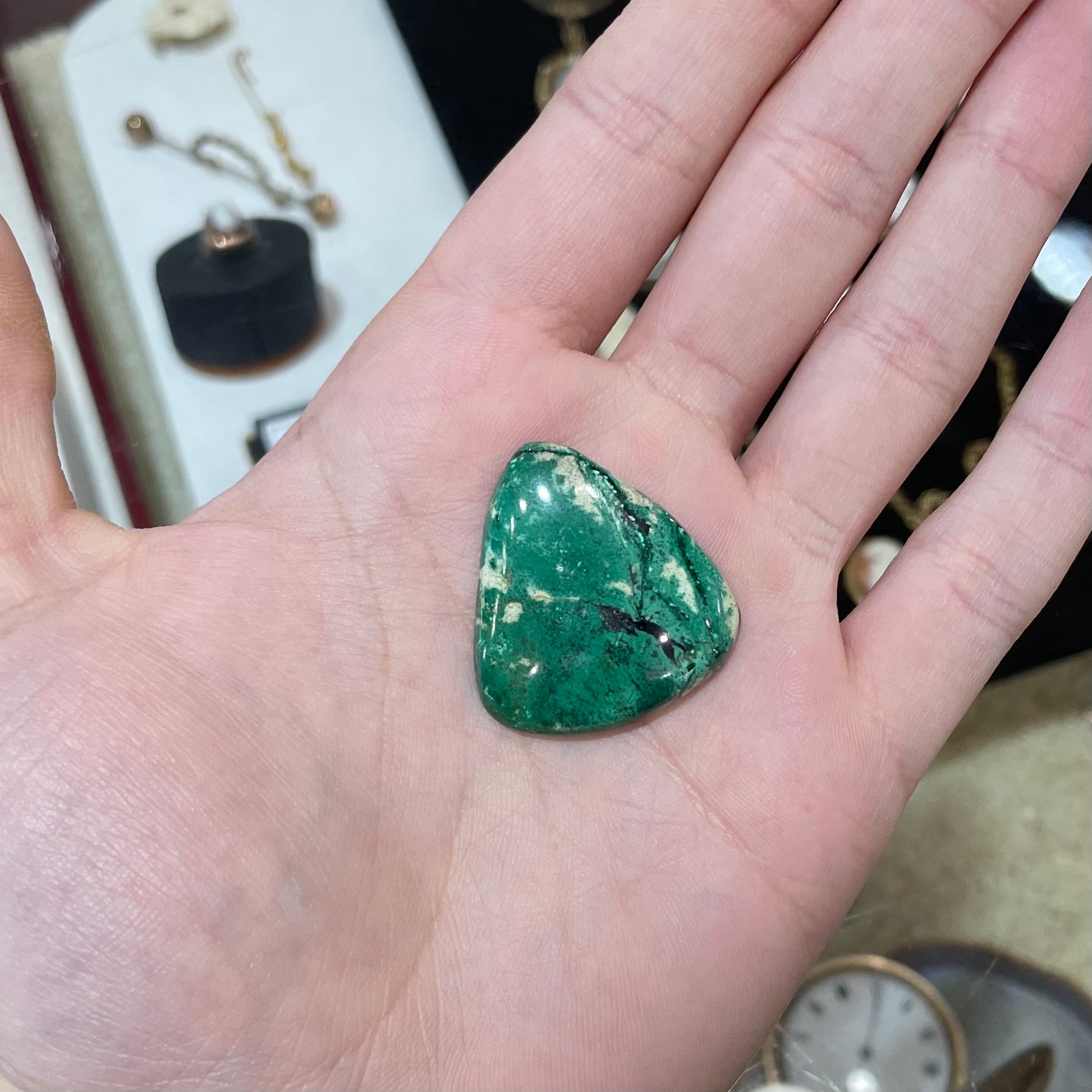 A loose, triangular cabochon cut variscite stone from Utah, USA.