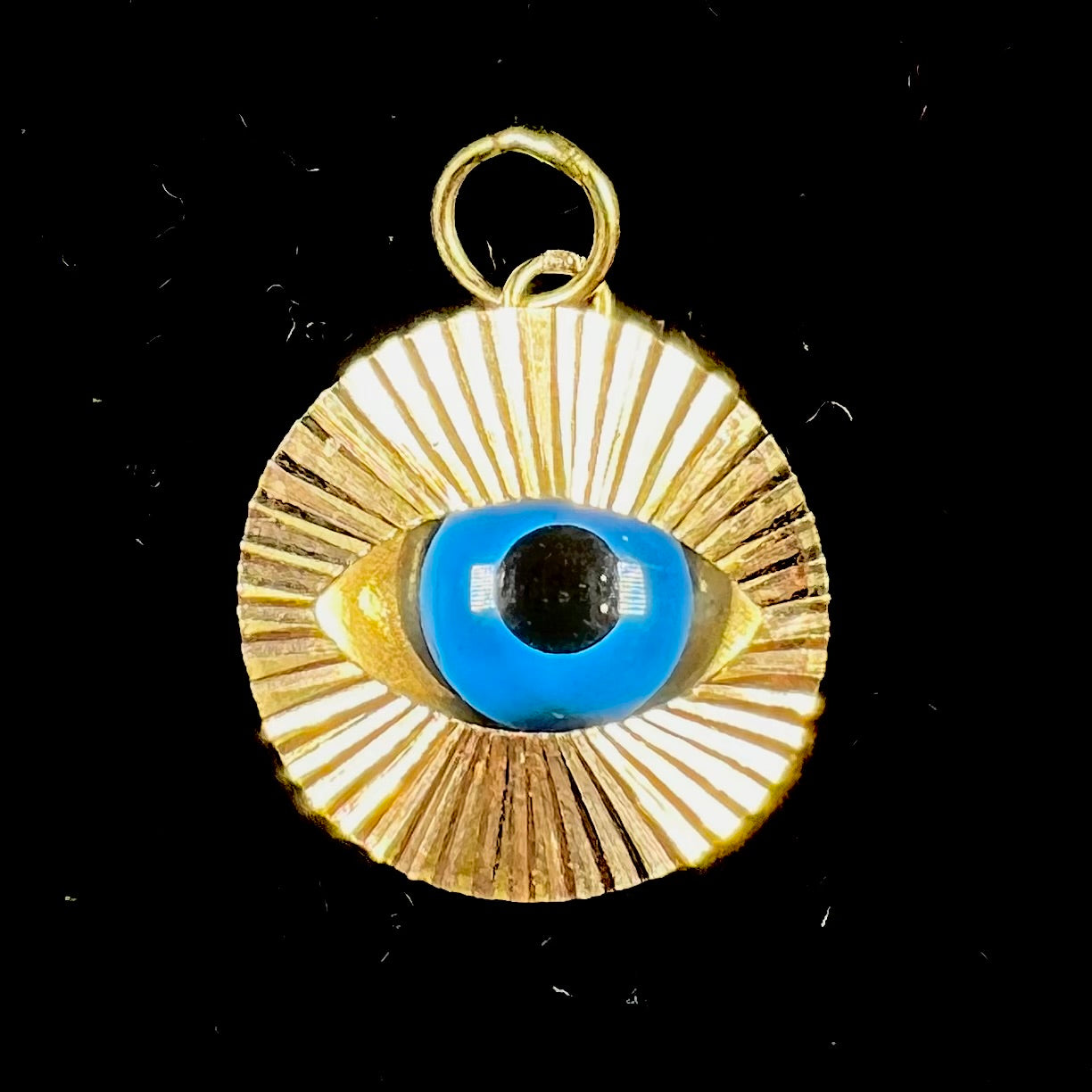 An 18kt yellow gold all-seeing eye pendant with a moving glass eye.