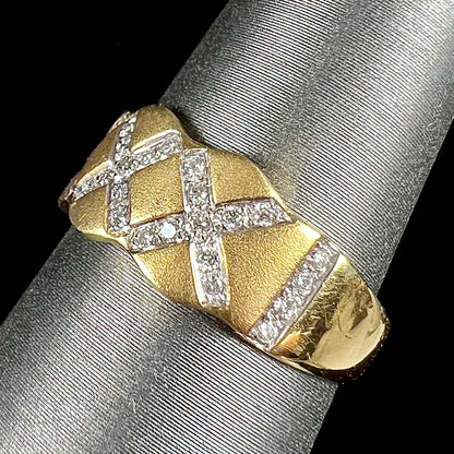 An 18kt yellow gold ring with three "X" shapes pave set with round diamonds.