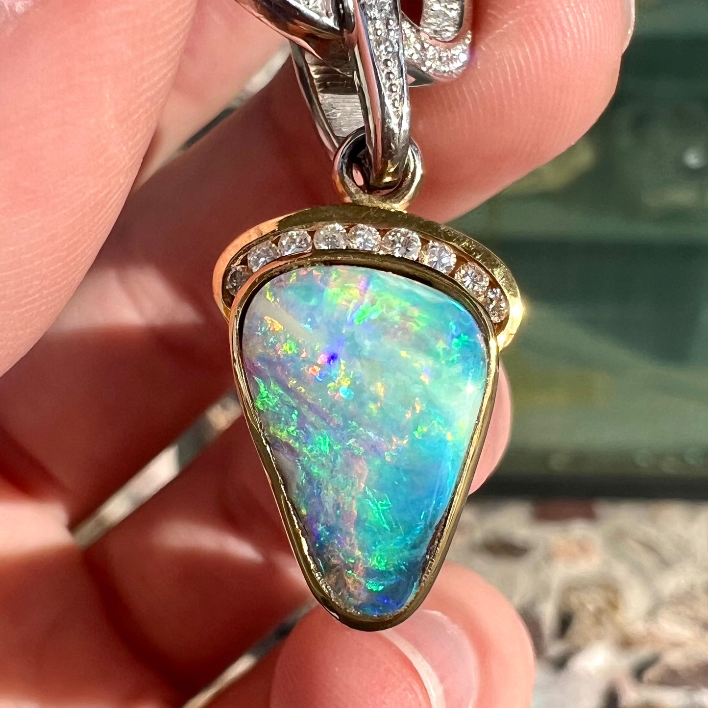 A ladies' 18kt two tone white and yellow gold Australian black boulder opal and diamond pendant.