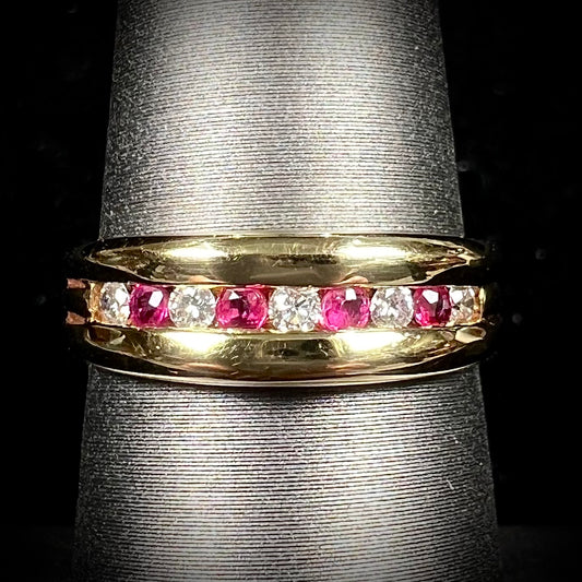 An 18kt yellow gold band channel set with round cut rubies and diamonds.