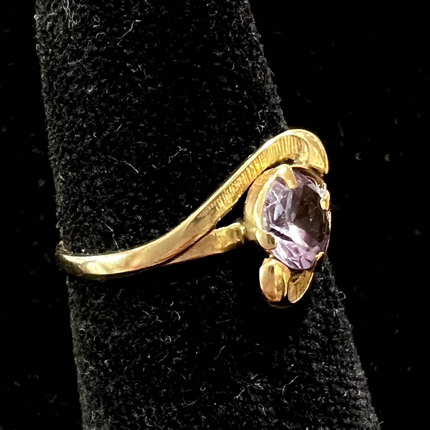 A vintage 1960's yellow gold ring set with a round synthetic purple alexandrite.  The prongs are worn.