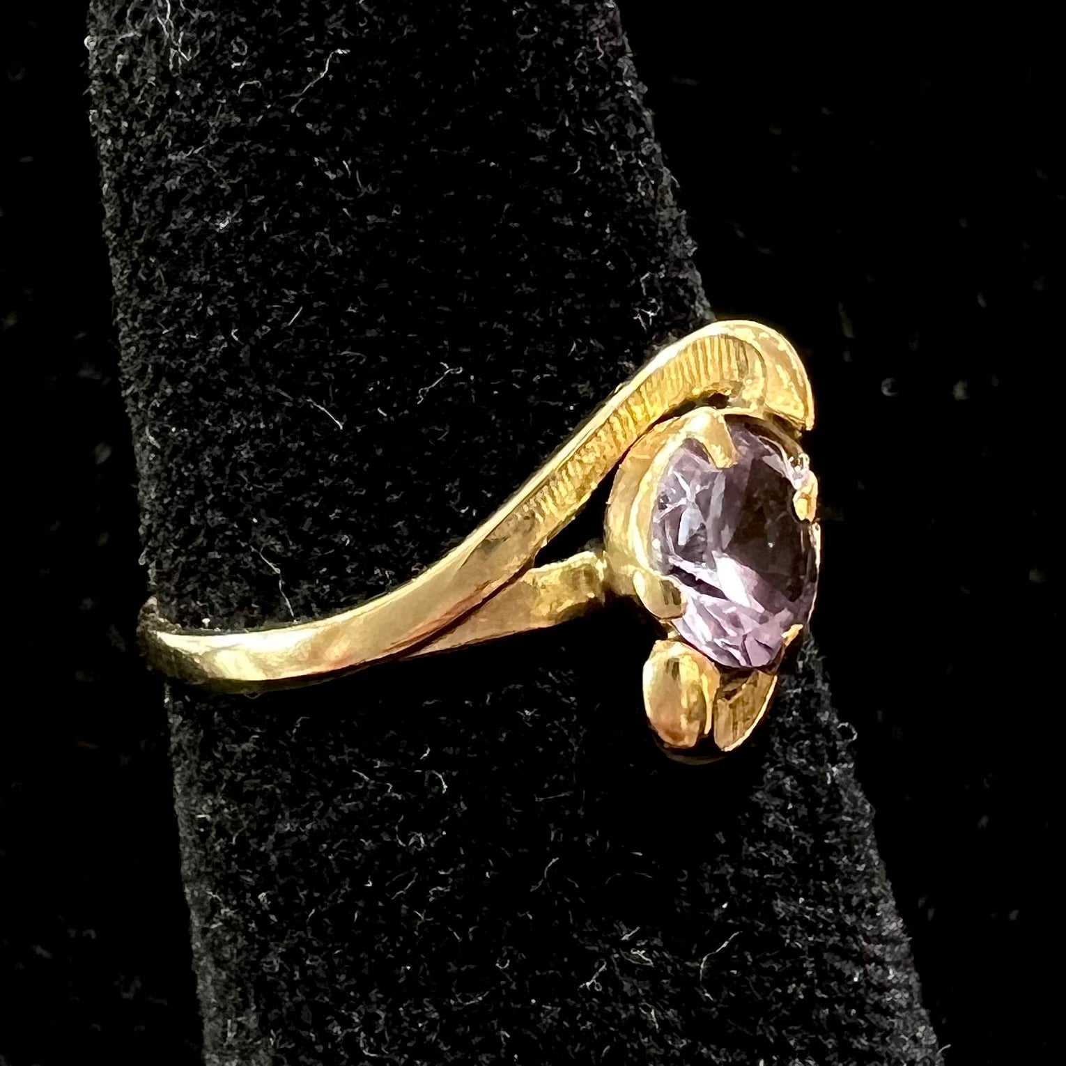 A vintage 1960's yellow gold ring set with a round synthetic purple alexandrite.  The prongs are worn.