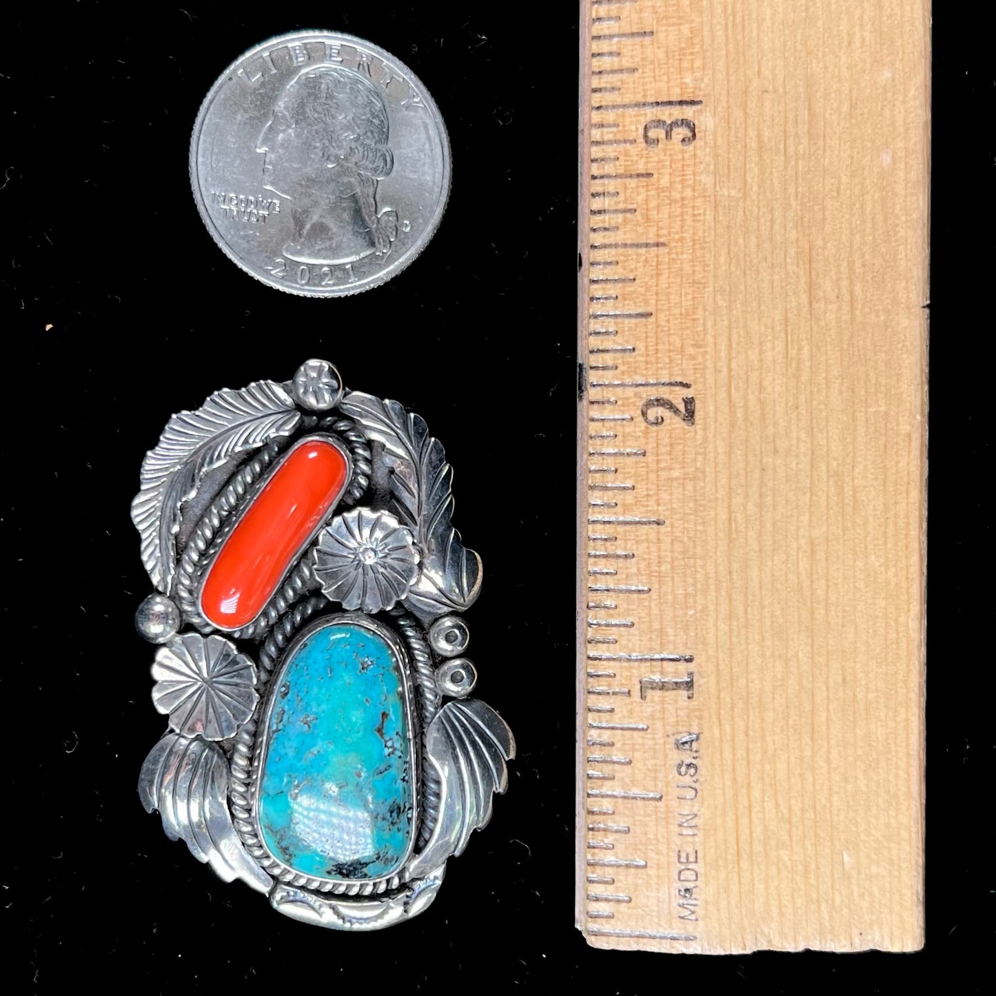 A sterling silver, 1970's Navajo pendant set with Kingman turquoise and coral stones, handmade by artist Angela Lee.