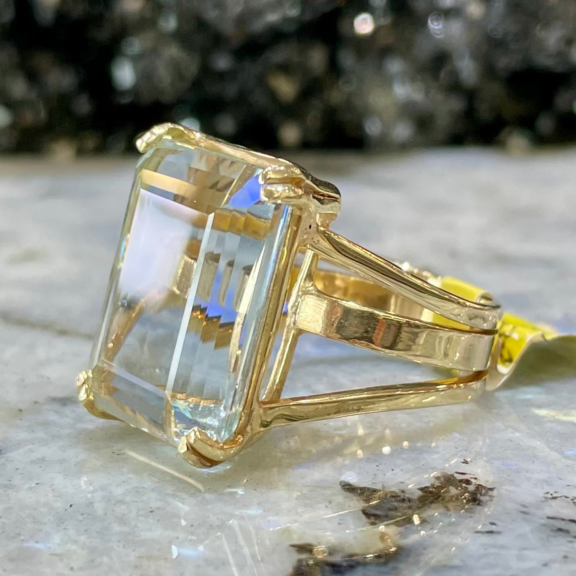 Large ladies' emerald cut aquamarine solitaire cocktail ring in yellow gold.