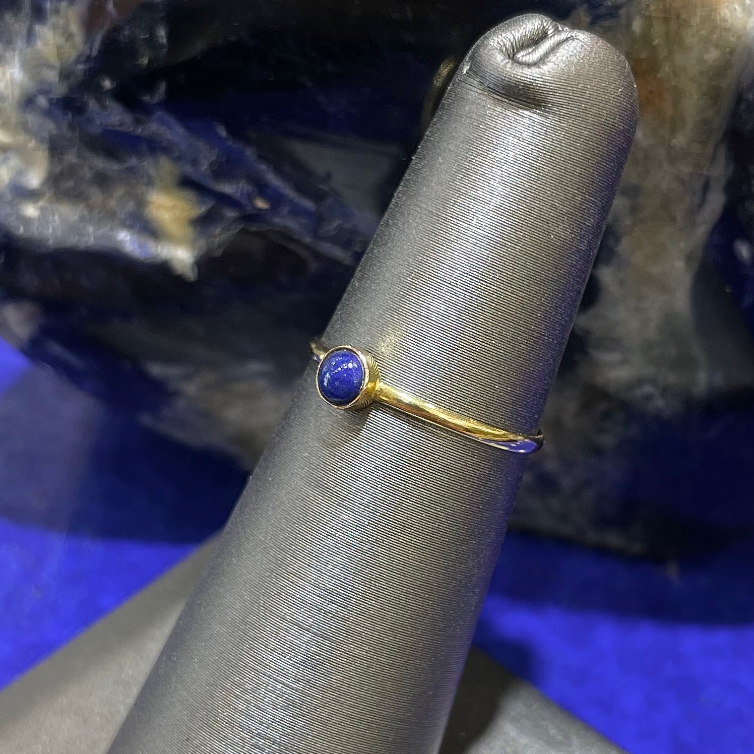 Round cabochon cut blue lapis lazuli stone set in a dainty simple yellow gold solitaire ring.