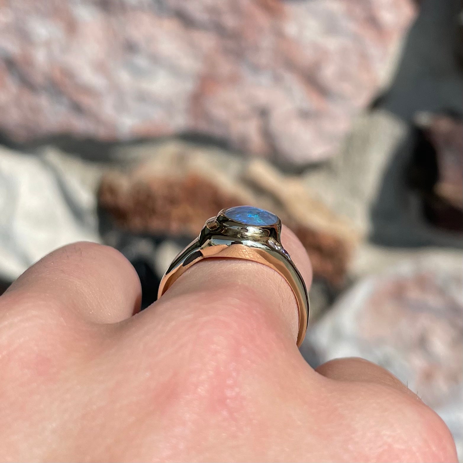 A yellow gold ring set with diamonds and a Lightning Ridge black opal from Australia.