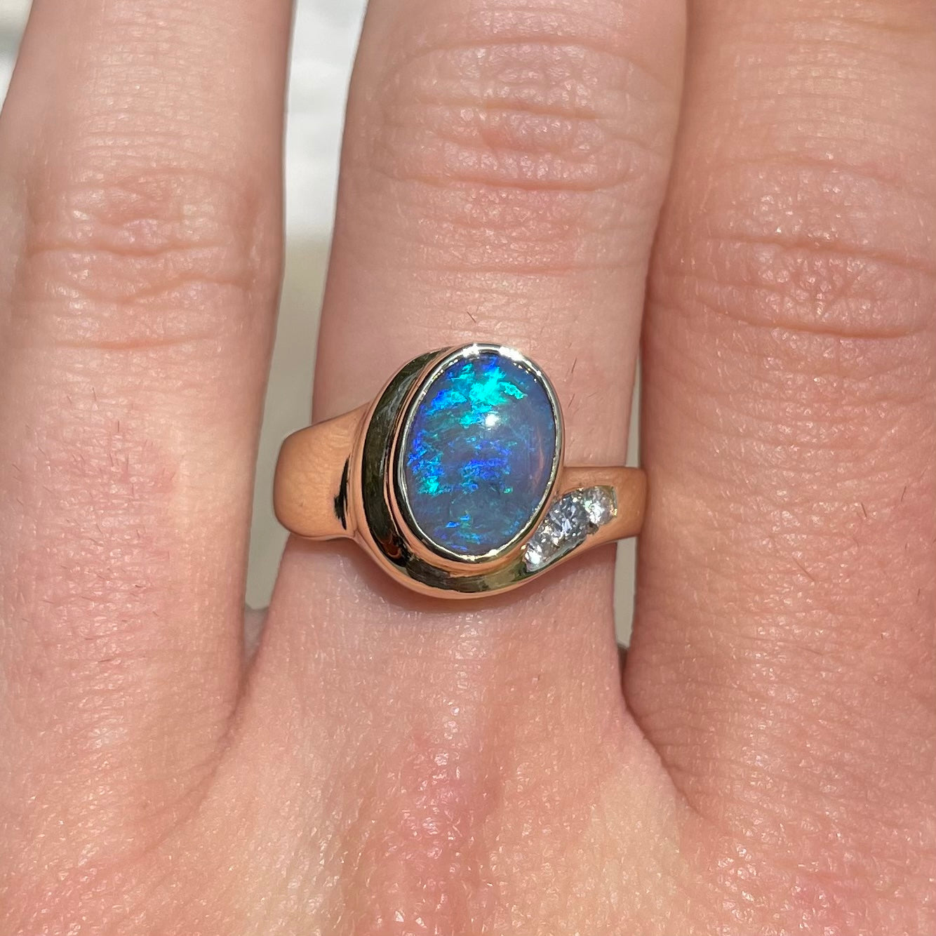 A yellow gold ring set with diamonds and a Lightning Ridge black opal from Australia.