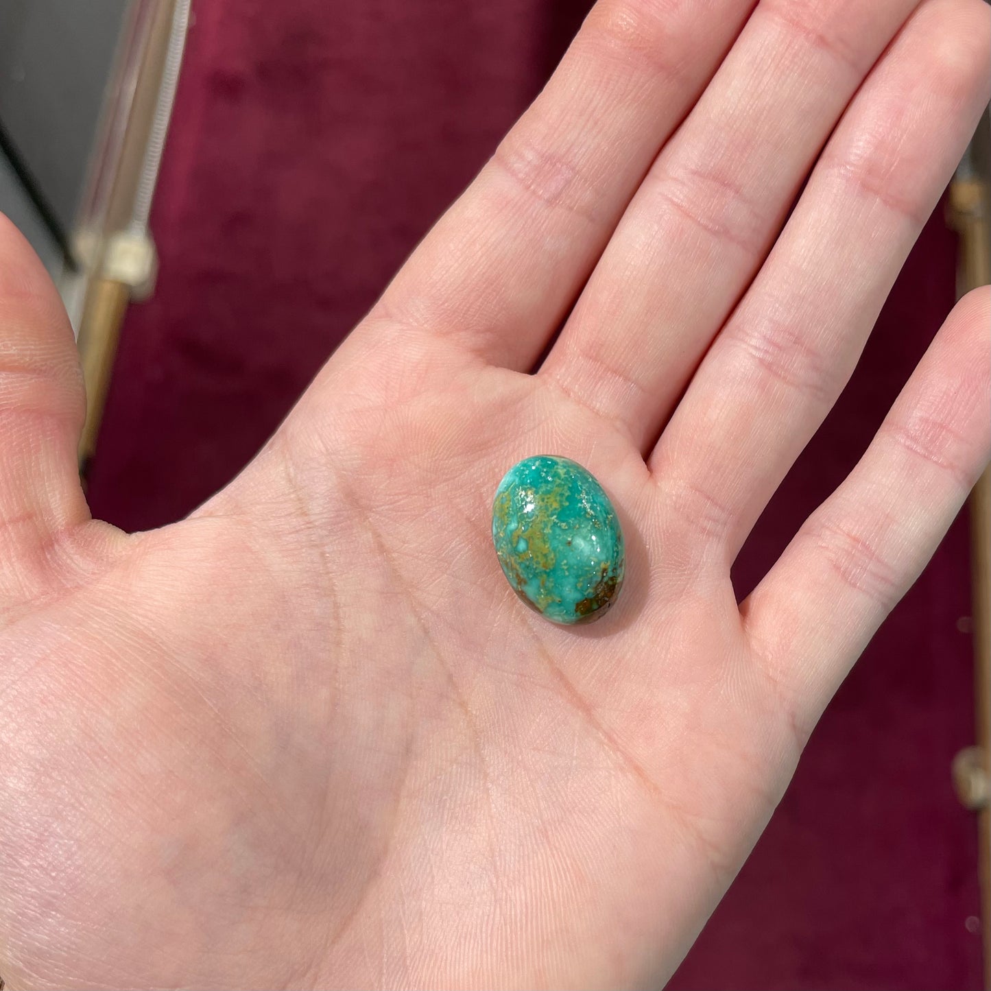 A loose, oval cabochon cut, green turquoise stone from Royston Mining District, Nevada.