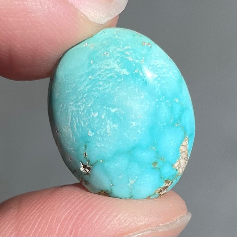 A loose, oval cabochon cut blue turquoise stone from Sonora, Mexico.