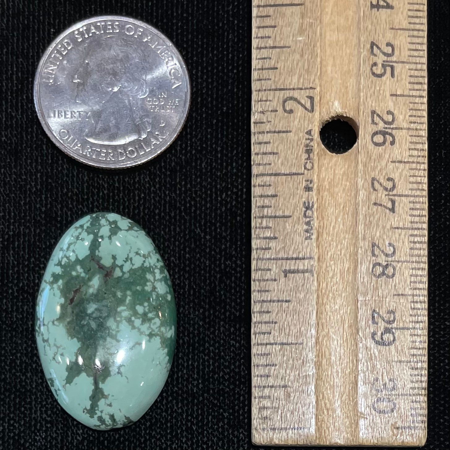 A loose, oval cabochon cut variscite stone from Utah, USA.
