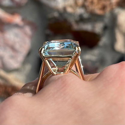 Large ladies' emerald cut aquamarine solitaire cocktail ring in yellow gold.