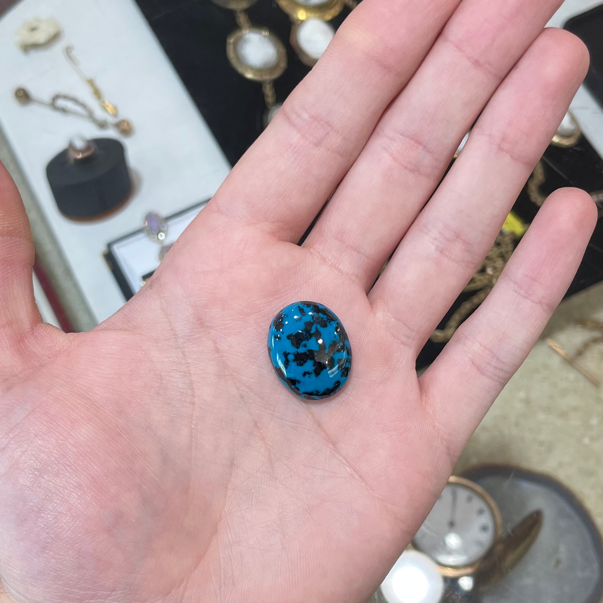 A loose, oval cabochon cut chrysocolla cabochon.