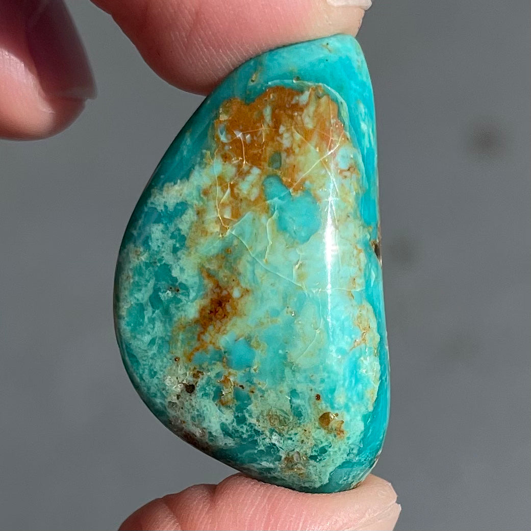 A loose freeform cut turquoise stone from the Royston Mining District in Nevada.