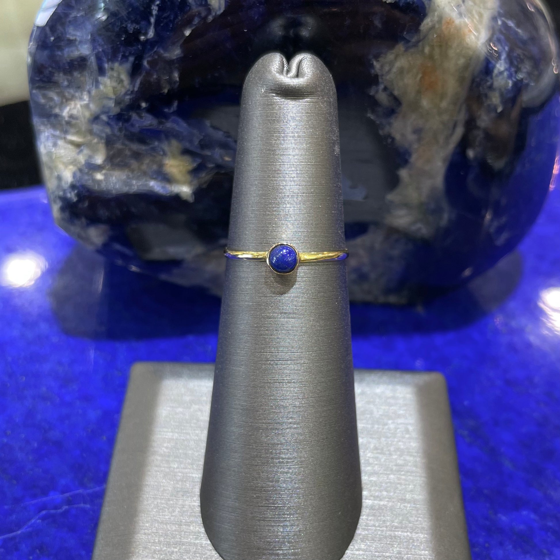 Round cabochon cut blue lapis lazuli stone set in a dainty simple yellow gold solitaire ring.