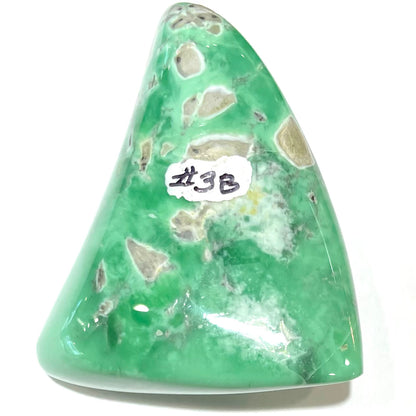 A loose, polished triangular cabochon cut variscite stone from Utah, USA.