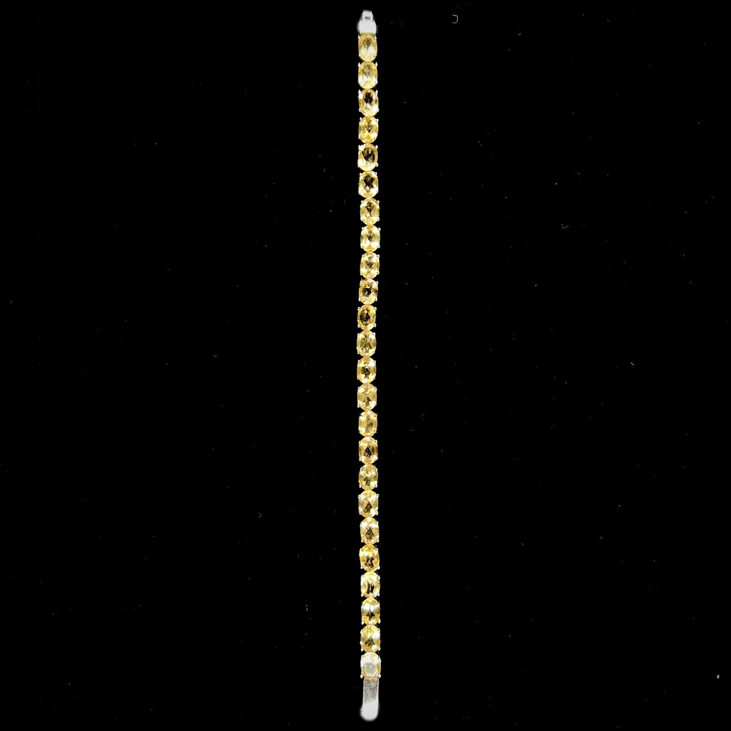 A sterling silver ladies' tennis bracelet set with faceted oval cut citrine stones.