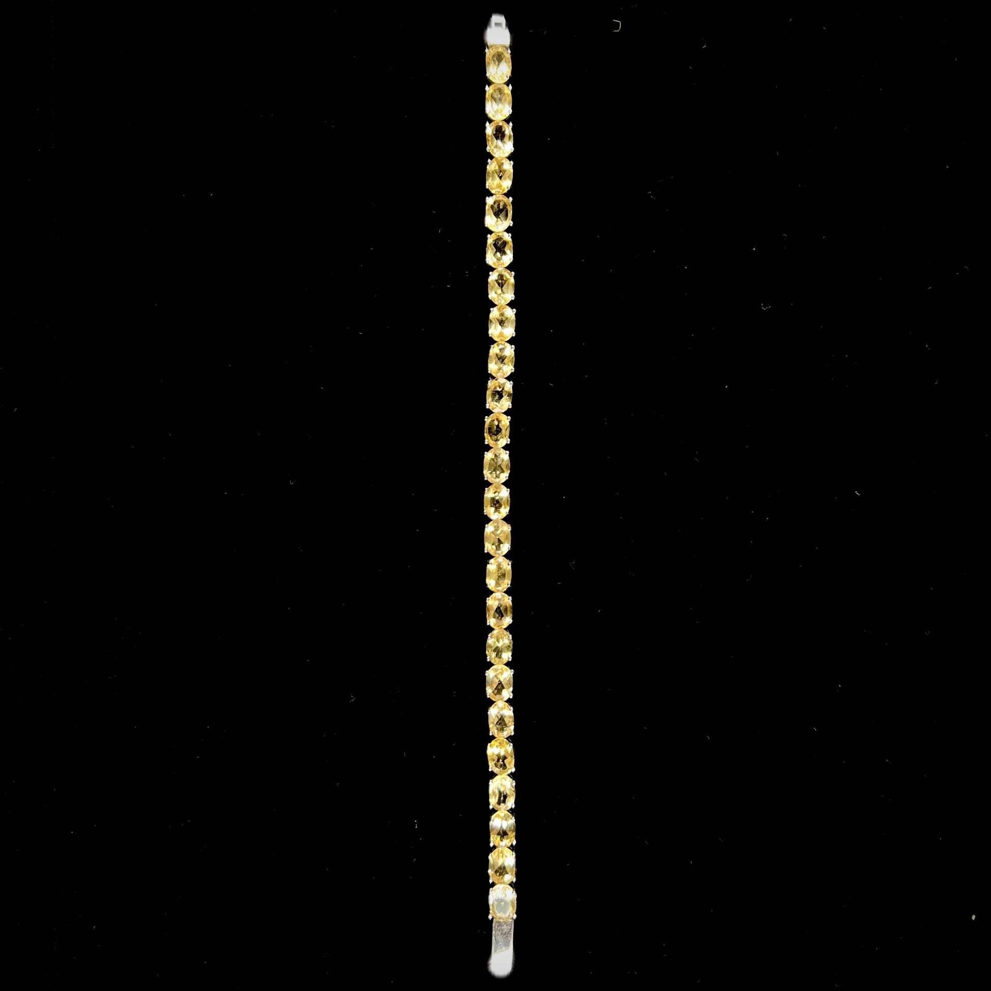 A sterling silver ladies' tennis bracelet set with faceted oval cut citrine stones.