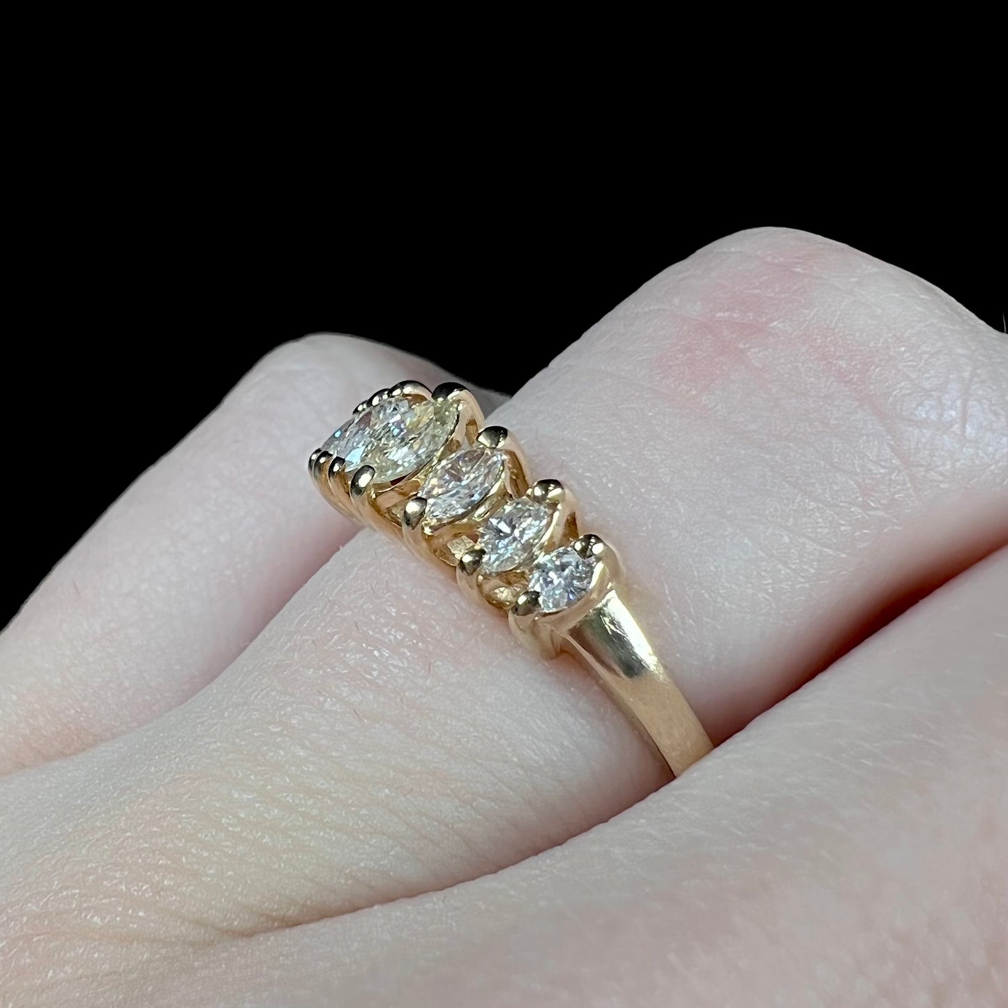 An estate yellow gold ring prong set with seven marquise cut diamonds.