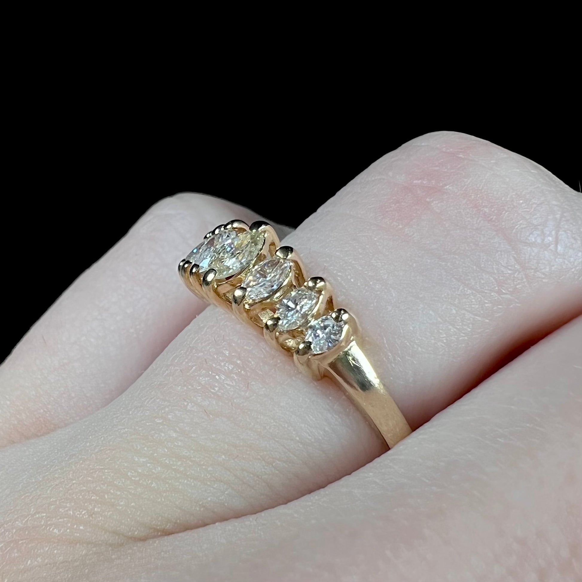 An estate yellow gold ring prong set with seven marquise cut diamonds.
