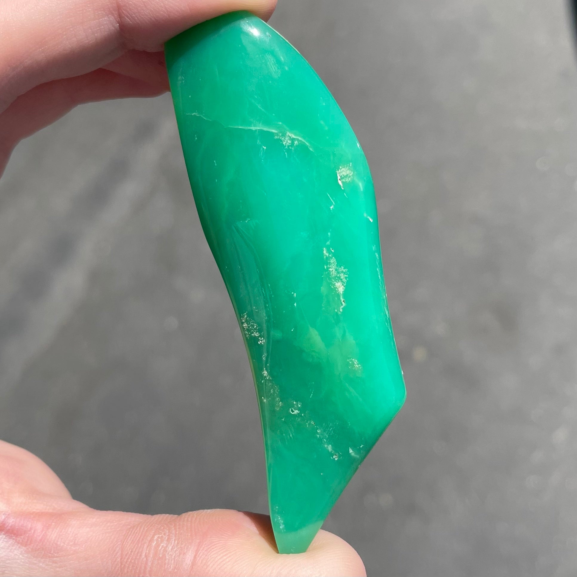A polished, freeform shape chrysocolla specimen that measures 3.3 inches by 1 inch.