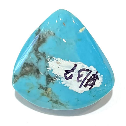 A loose, triangular cabochon cut blue turquoise stone from Sleeping Beauty Mine, Arizona.