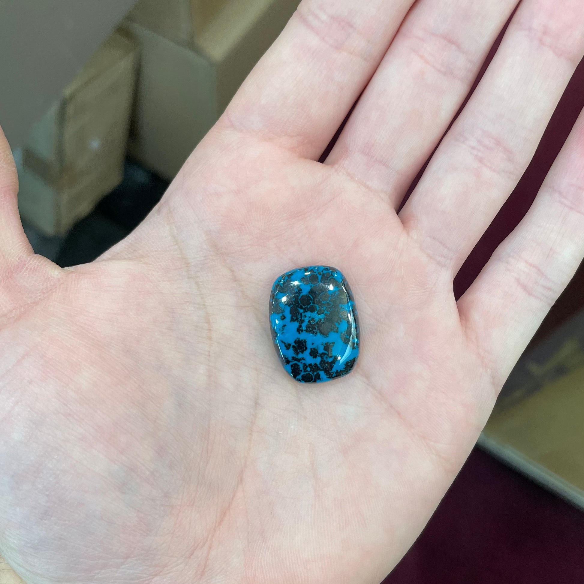 A loose, cushion cabochon cut chrysocolla stone.