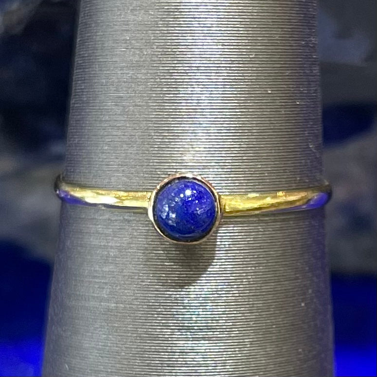 Round cabochon cut blue lapis lazuli stone set in a dainty simple yellow gold solitaire ring.