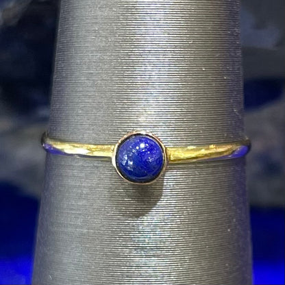 Round cabochon cut blue lapis lazuli stone set in a dainty simple yellow gold solitaire ring.