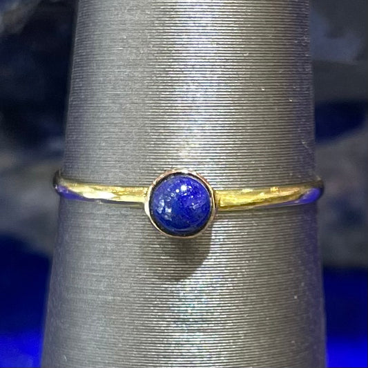 Round cabochon cut blue lapis lazuli stone set in a dainty simple yellow gold solitaire ring.