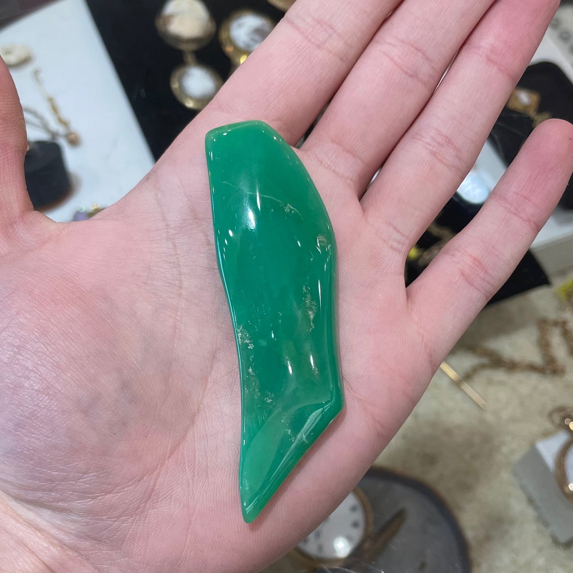 A polished, freeform shape chrysocolla specimen that measures 3.3 inches by 1 inch.