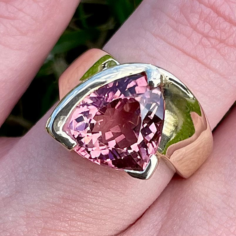 A unisex trillion cut pink tourmaline ring half bezel set in 14k yellow gold.