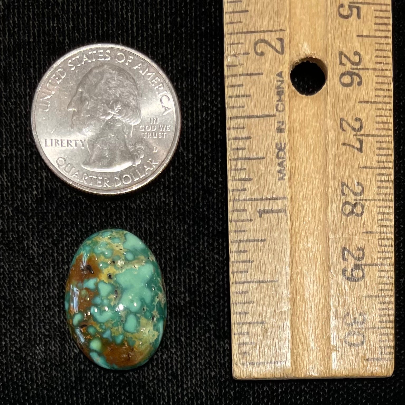 A loose, oval cabochon cut green and brown turquoise stone from Royston Mining District, Nevada.