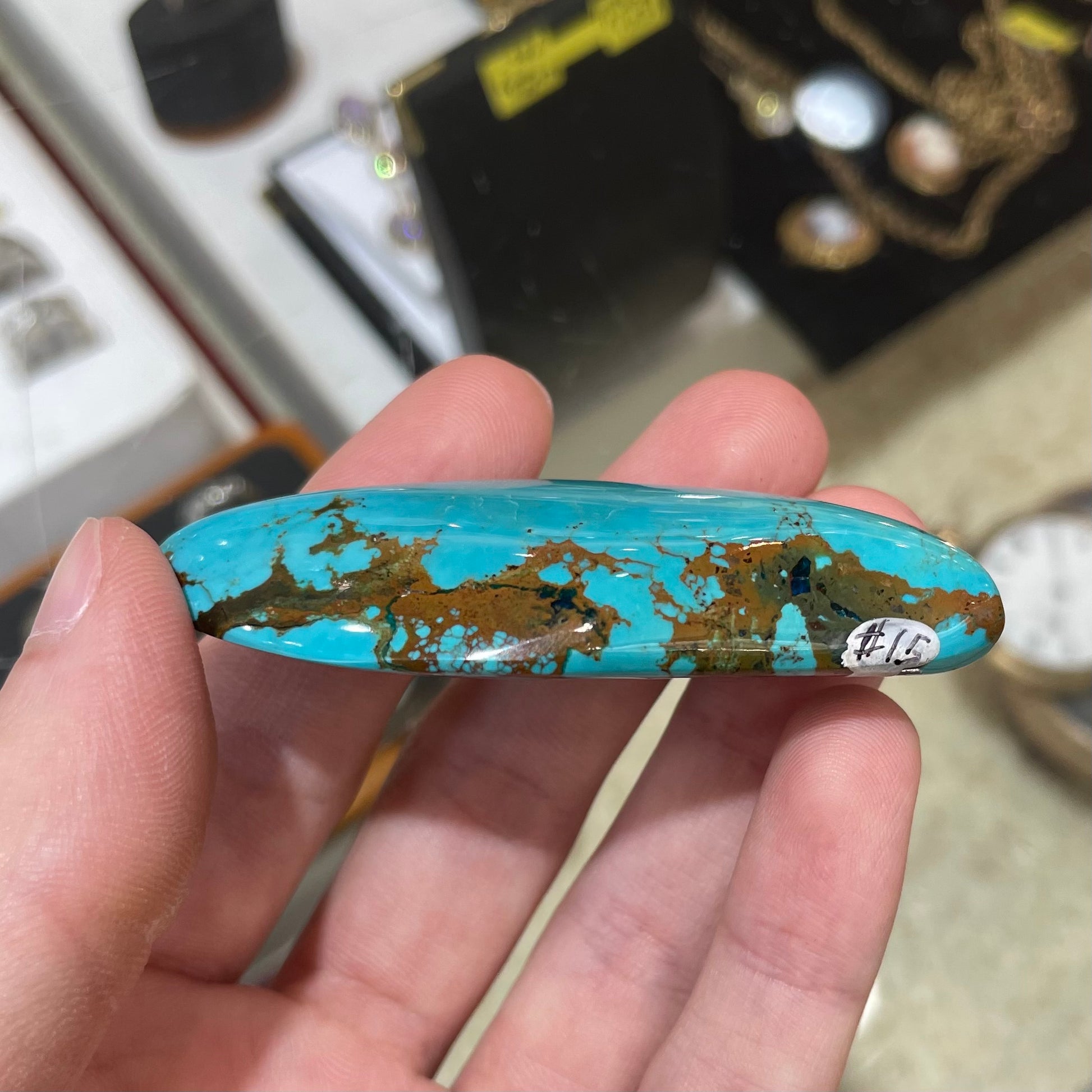 A freeform cabochon cut Bisbee turquoise stone.  The stone has been dyed to improve color.