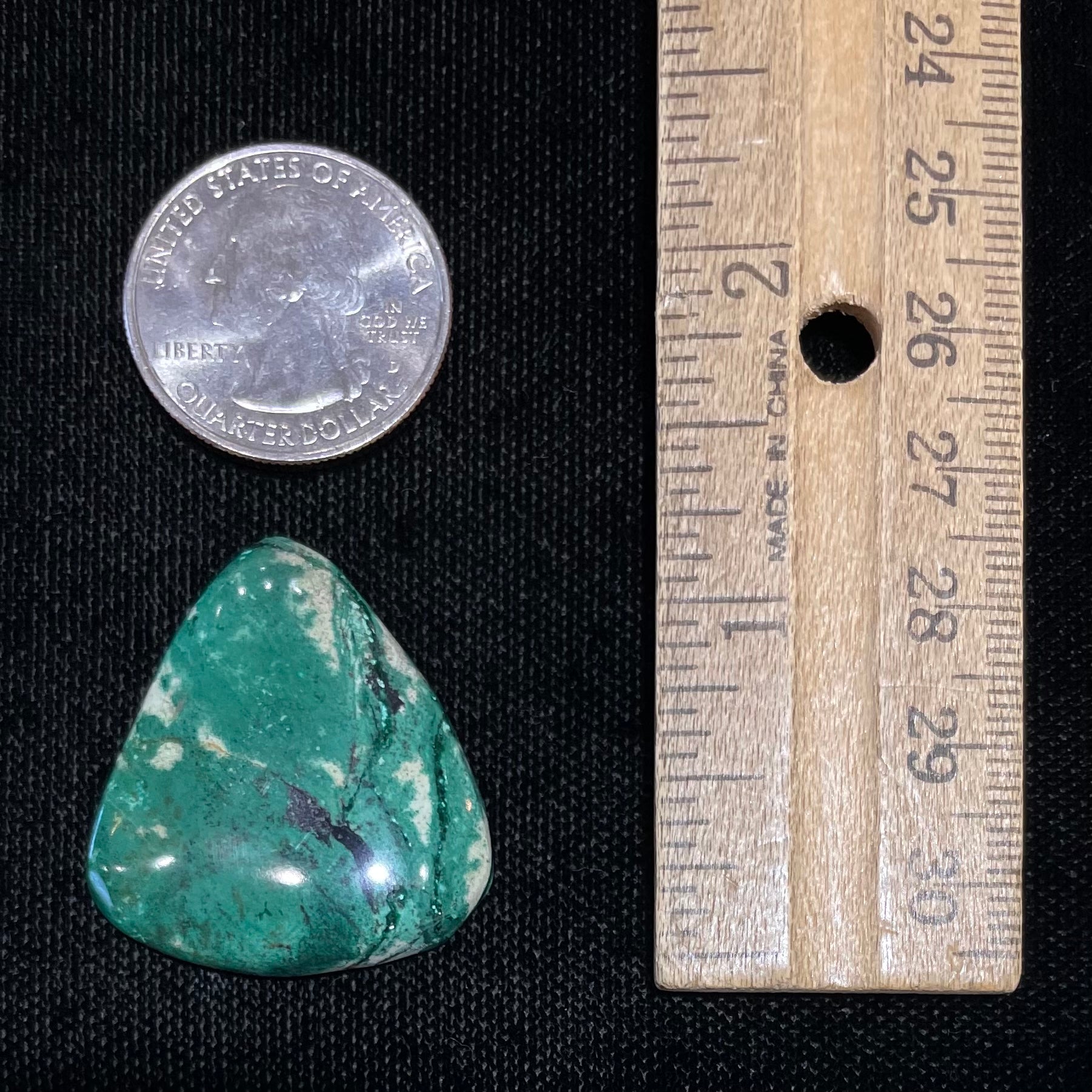 A loose, triangular cabochon cut variscite stone from Utah, USA.