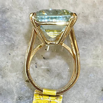 Large ladies' emerald cut aquamarine solitaire cocktail ring in yellow gold.