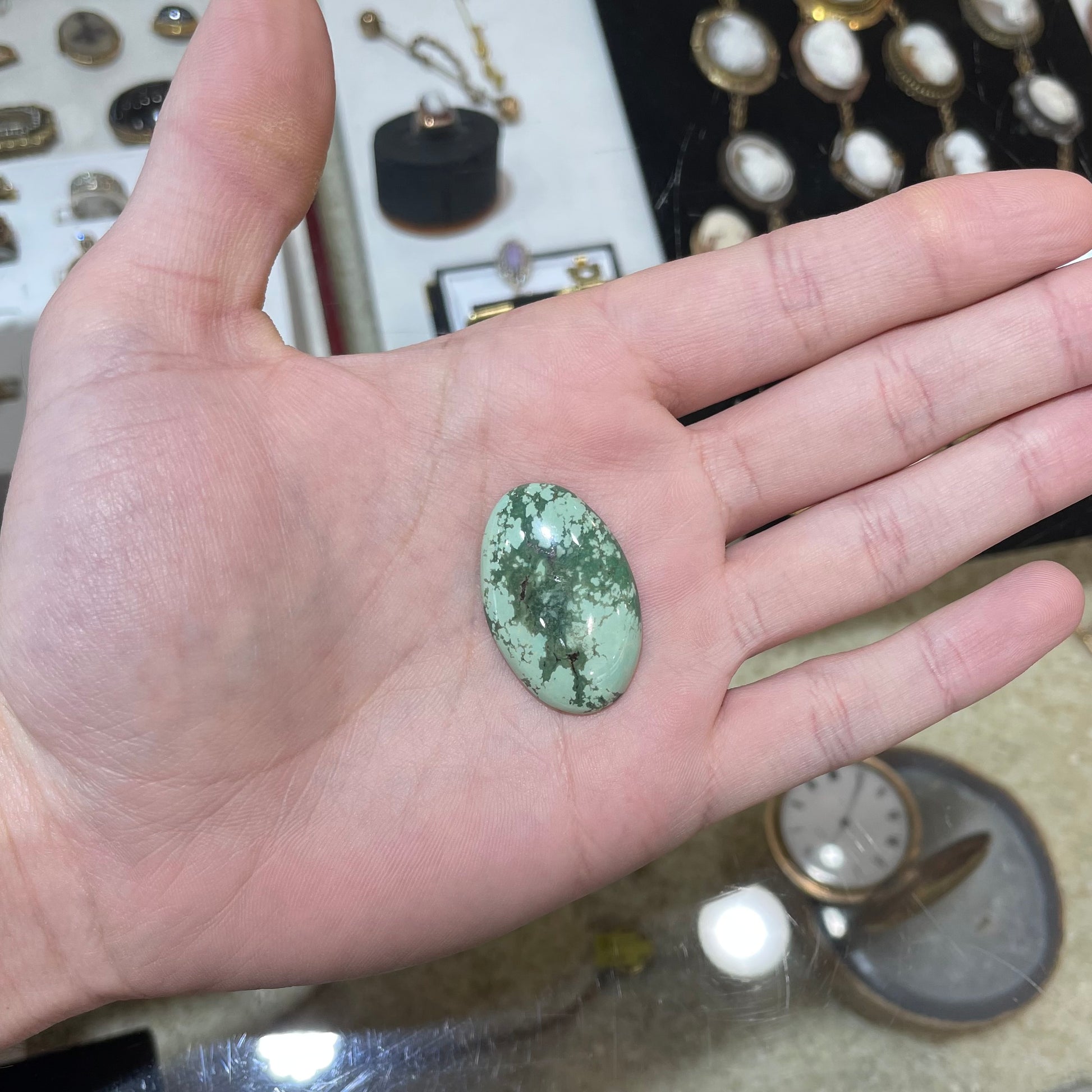 A loose, oval cabochon cut variscite stone from Utah, USA.
