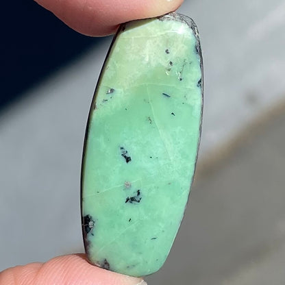 A loose, green turquoise stone cabochon from Royston Mining District, Arizona.