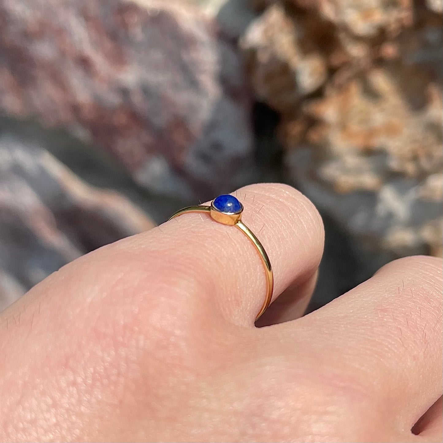 Round cabochon cut blue lapis lazuli stone set in a dainty simple yellow gold solitaire ring.