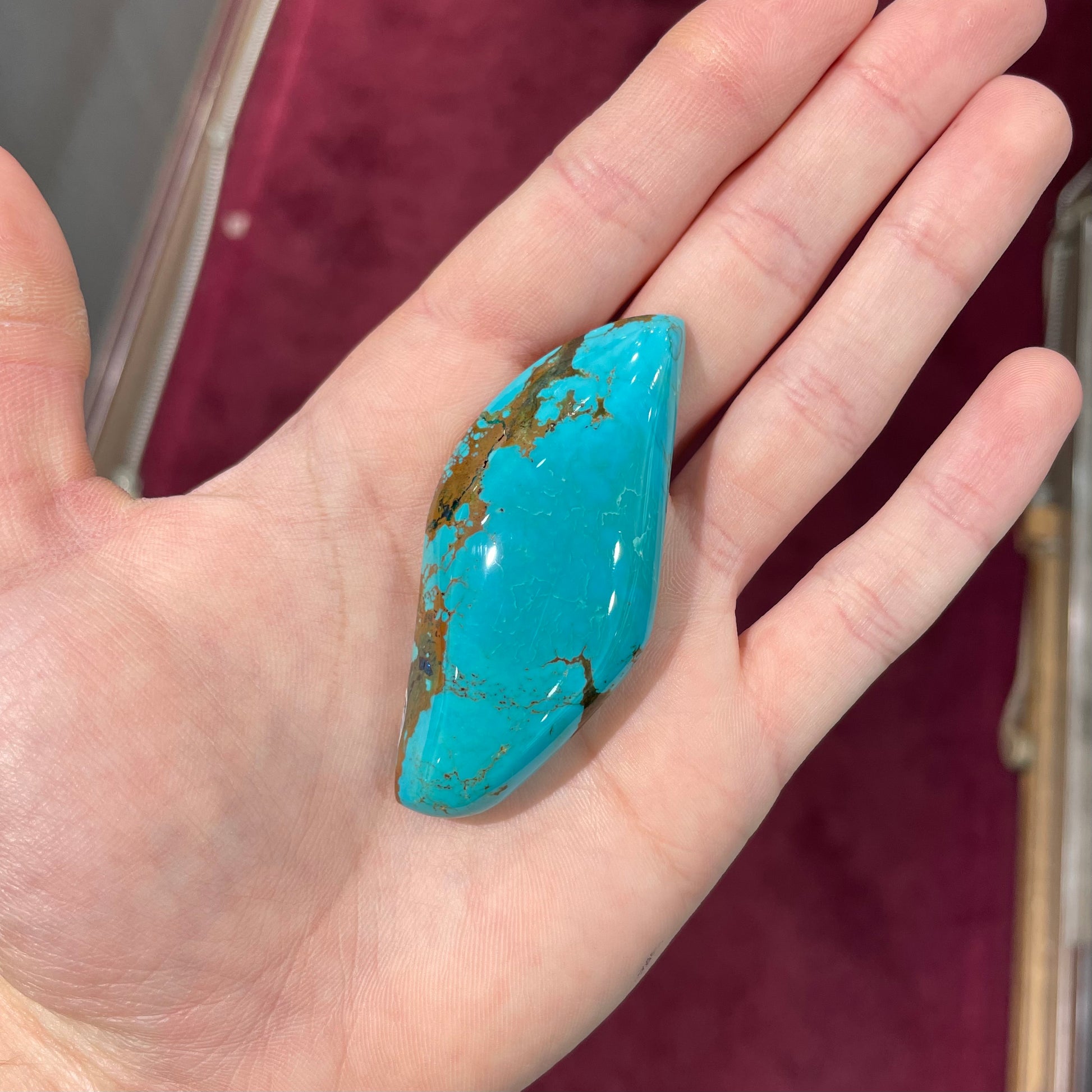 A freeform cabochon cut Bisbee turquoise stone.  The stone has been dyed to improve color.