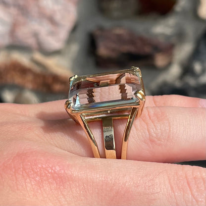 Large ladies' emerald cut aquamarine solitaire cocktail ring in yellow gold.