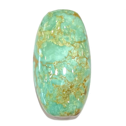 A loose, cabochon cut, green turquoise stone with brown matrix.