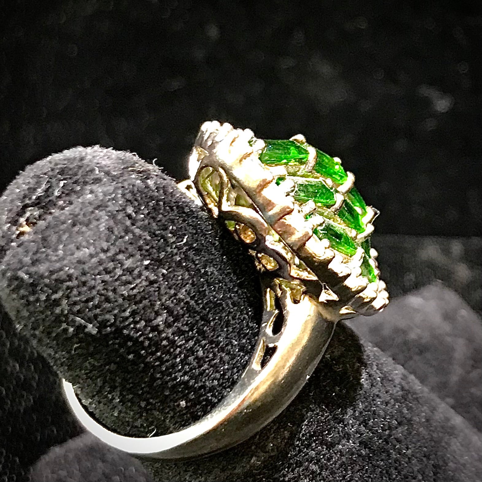 A sterling silver marquise shape ring set with green baguette cut stones.