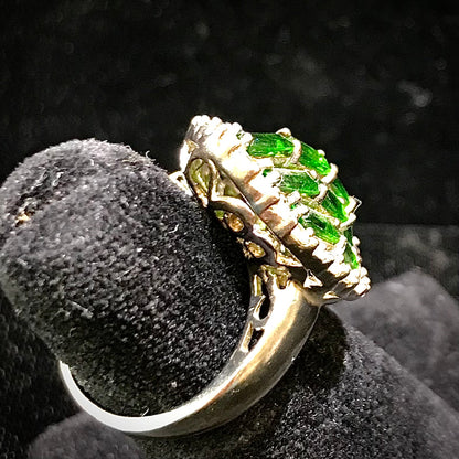 A sterling silver marquise shape ring set with green baguette cut stones.