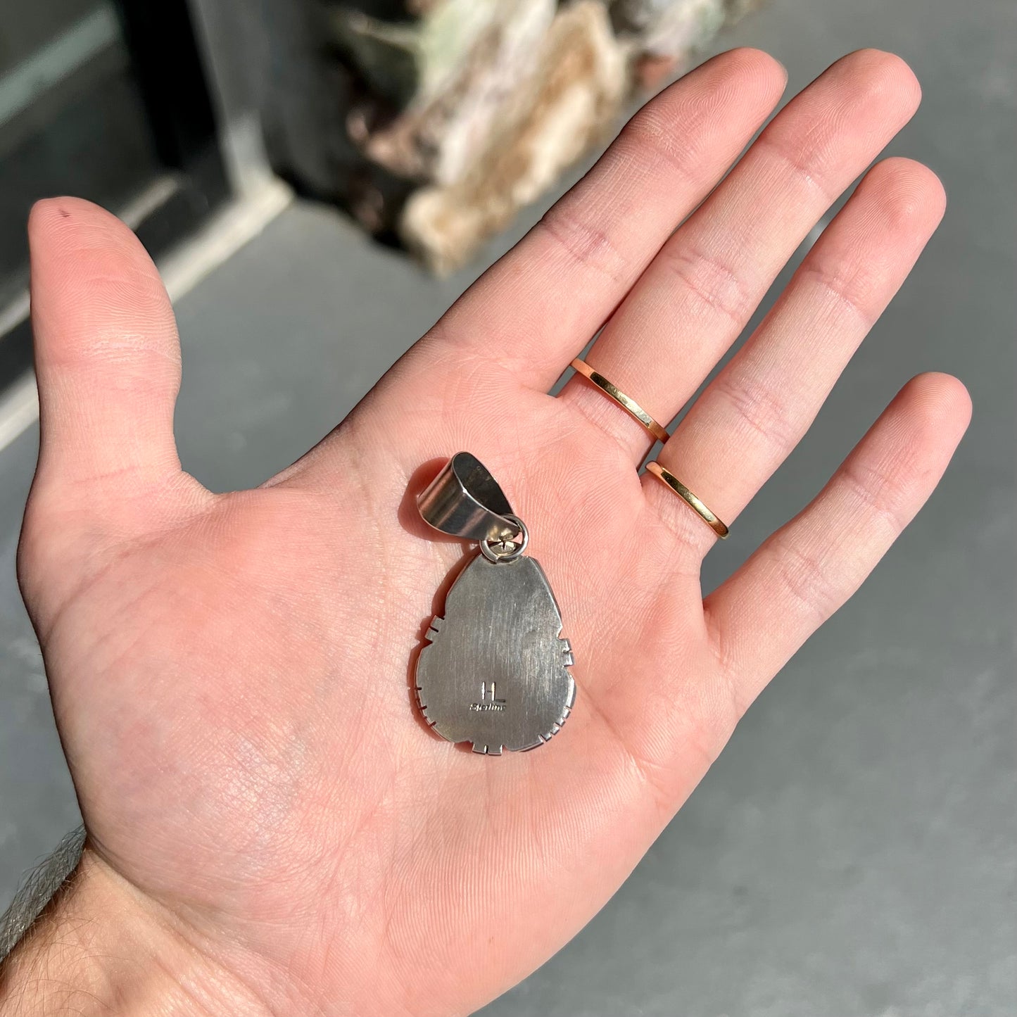 A sterling silver bezel set variscite stone pendant handmade by Navajo artist, Herman Lee.