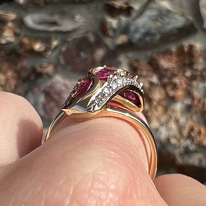 A custom freeform design yellow gold twisted shank ring set with five oval cut rubies and small round diamonds.