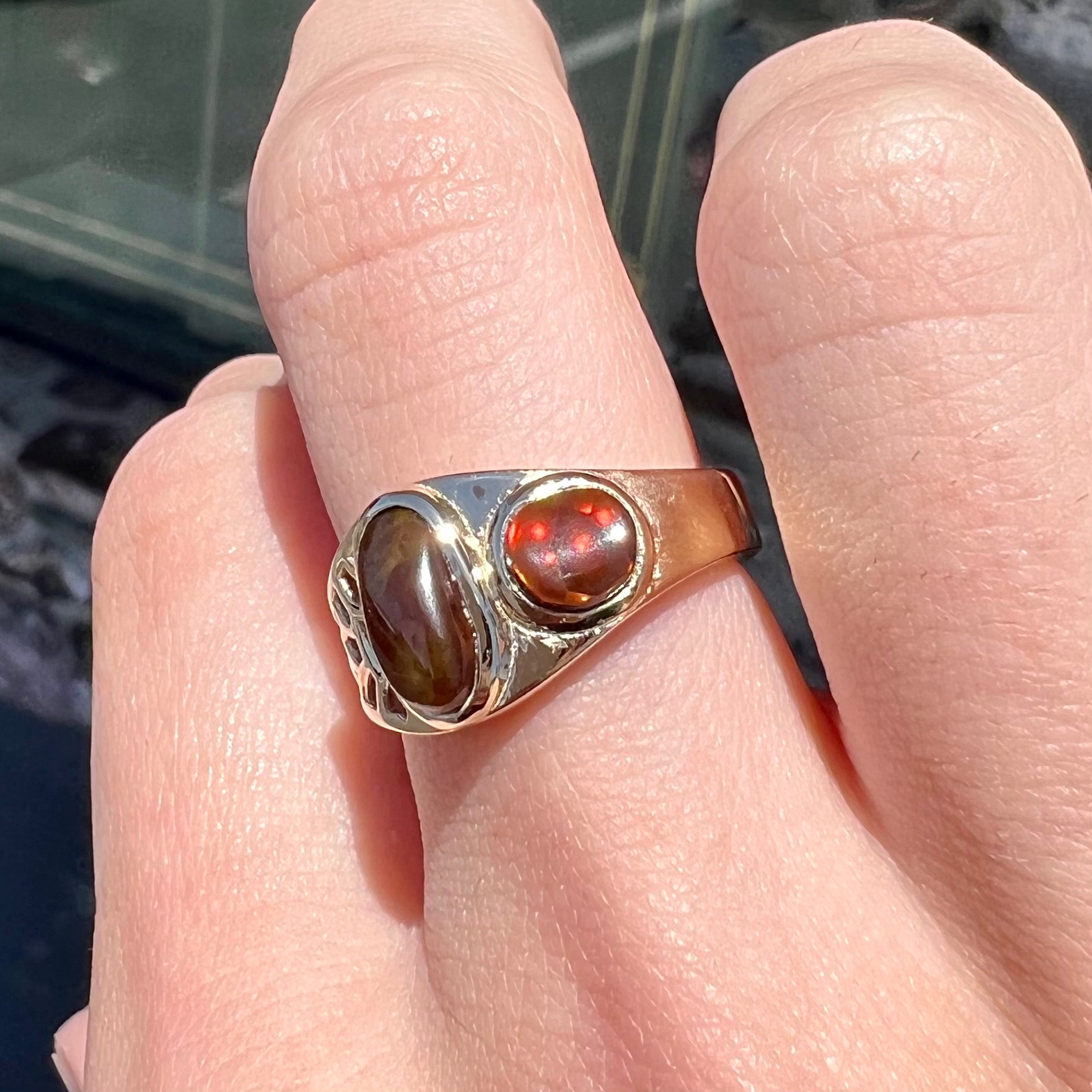 A ladies' yellow gold ring set with two fire agate stones: one green, and one red.