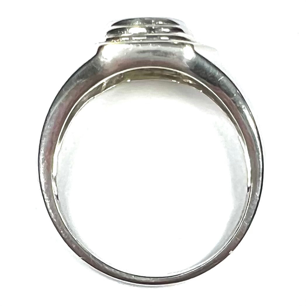 A sterling silver men's ring set with green peridot surrounded by baguette cut diamonds.